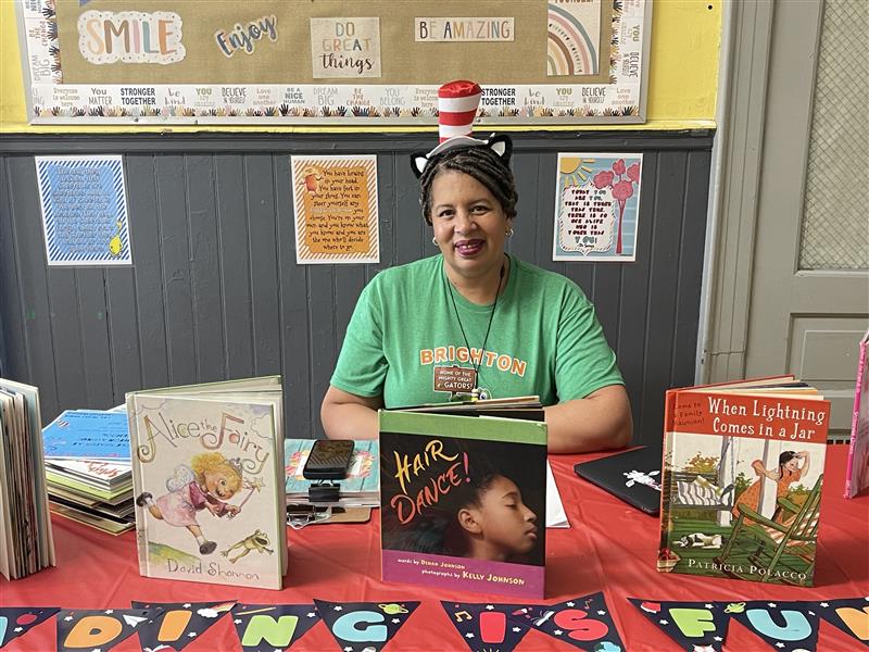 Tracee Oliver, the literacy coach for Brighton Avenue School, sits at a book table .