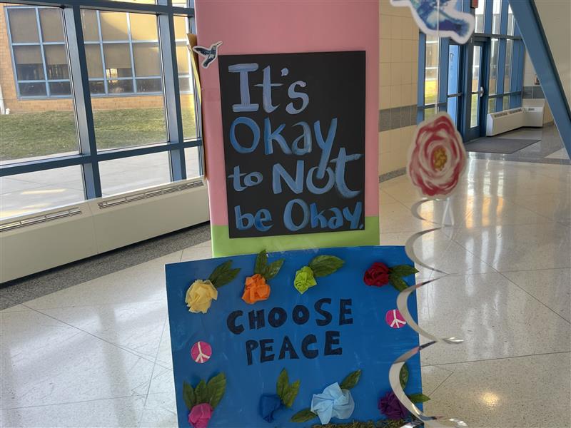 It's okay to not be okay. and Choose Peace signs hang in an Atlantic City High School.