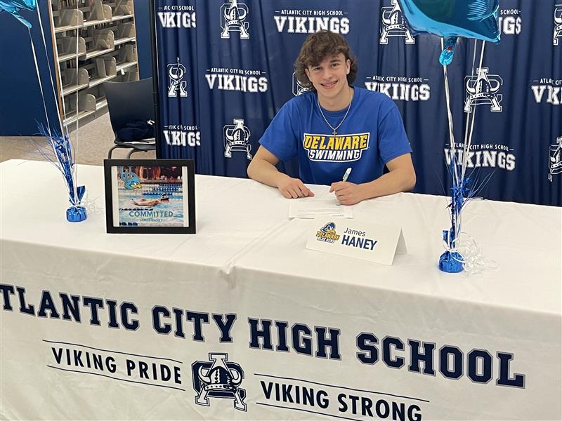 State Champion Swimmer James Haney signs college letter at Atlantic City High School.