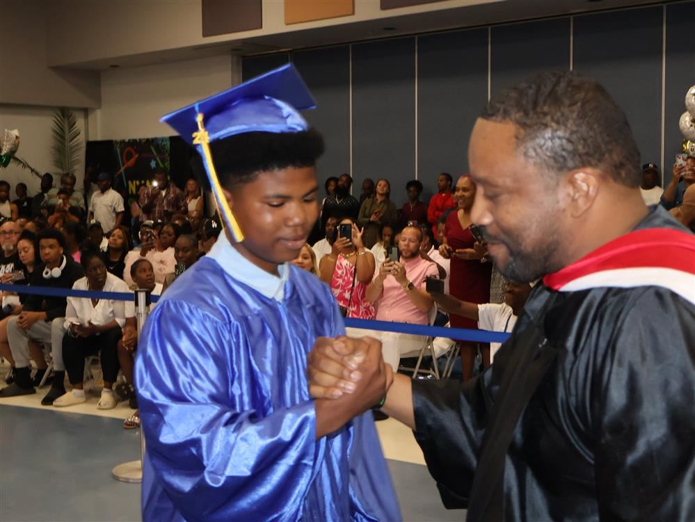 Principal and Student shake hands.