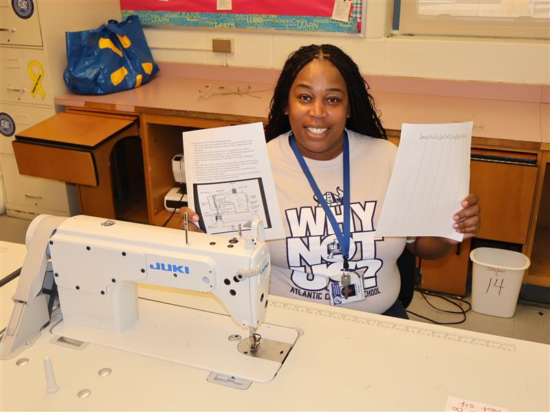 Clothing and textile teacher teaches students parts of the sewing machine.