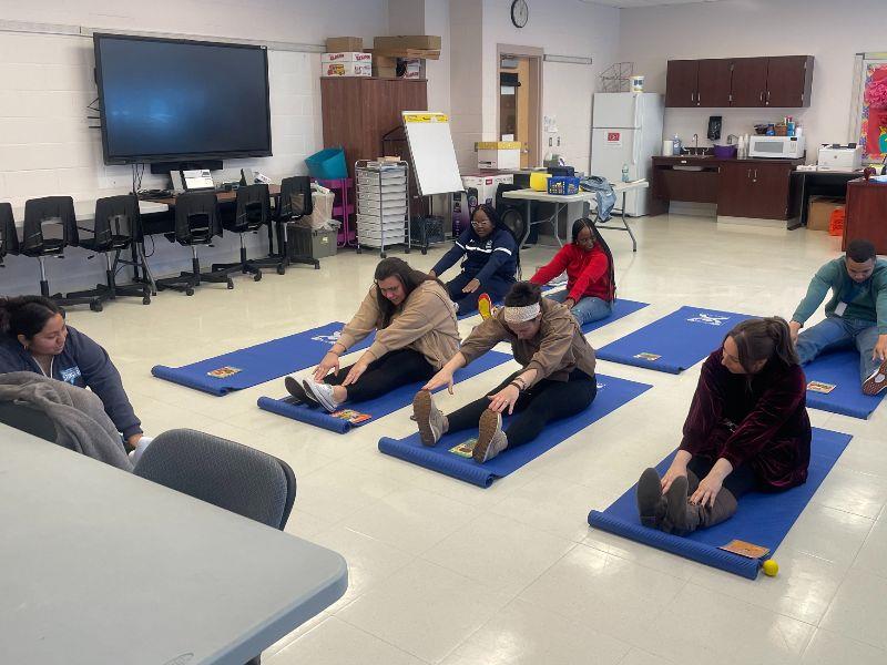 Richmond Avenue School SEL Teacher Coach Melissa Luna leads staff in yoga.